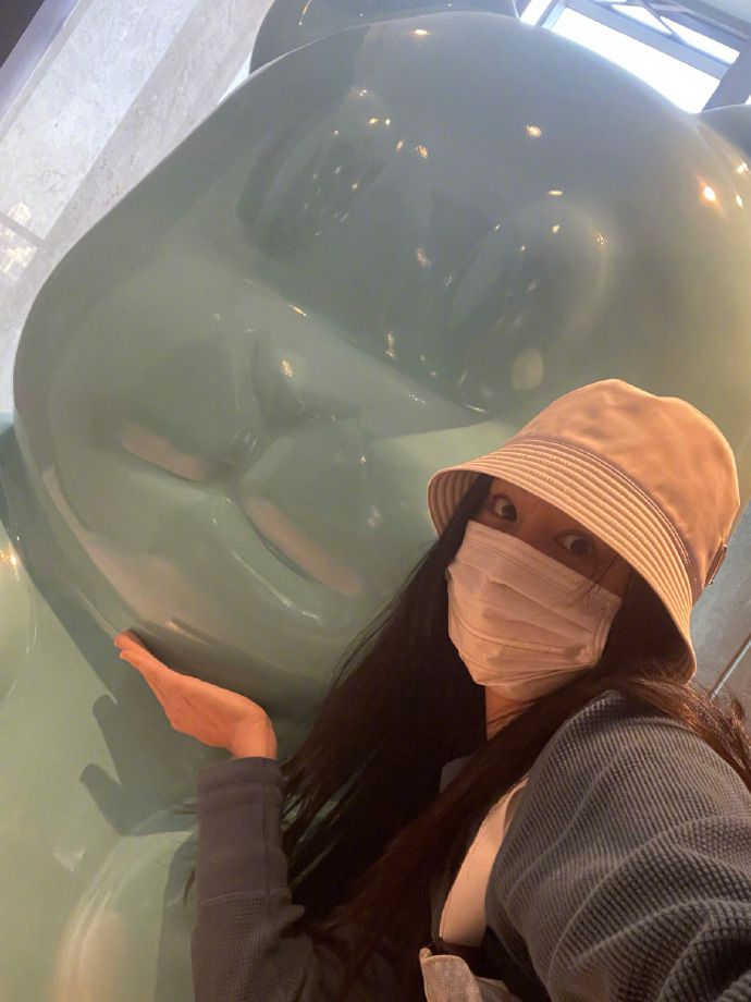 伊能静机场脱羽绒服穿灰裙 拖鞋换高跟短靴优雅出镜